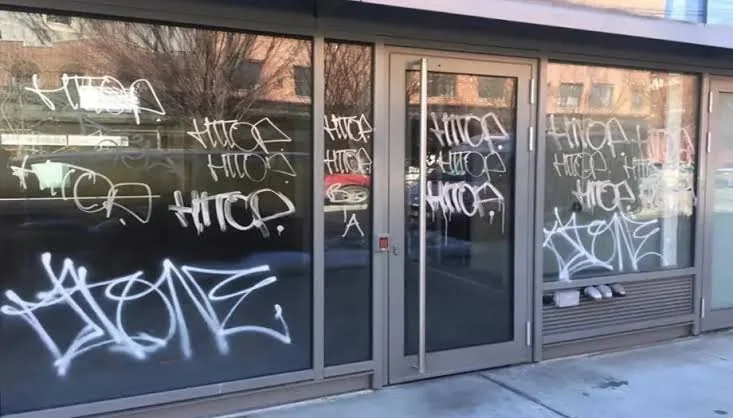 Shopfront windows and glass door covered in spray paint tags