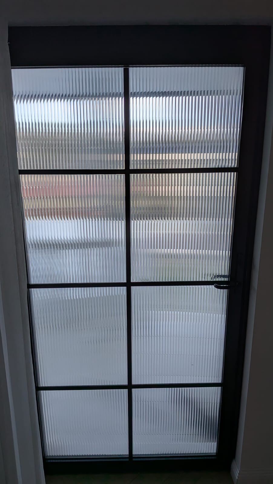 Reeded glass door with decorative window film